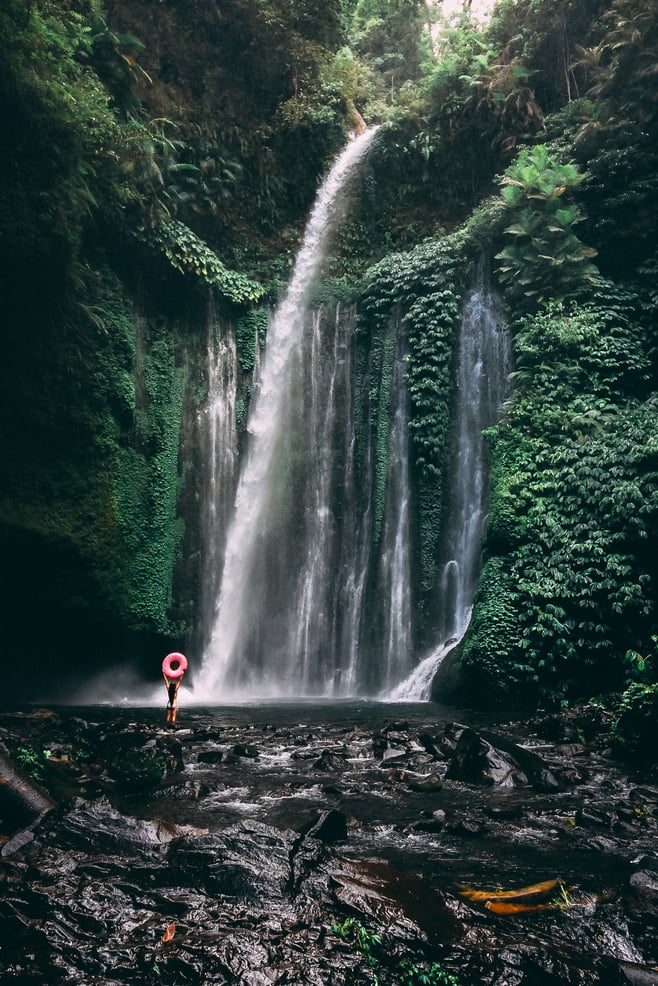 Person in Red Jacket Standing in Front of Waterfalls